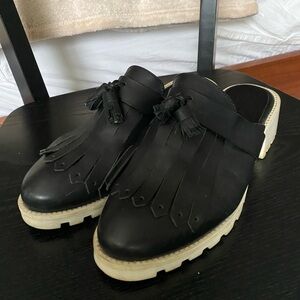 MIISTA Black and white leather mules with tassel detail